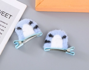 Detail of blue plush tiger ear hair clips with soft faux fur and secure metal duckbill base