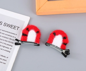 Detail view of plush red and white cat ear hair clips with polka dots and silver metal grips