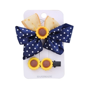 Navy blue polka dot bow hair clip and sunflower hairpin set for girls on a white card