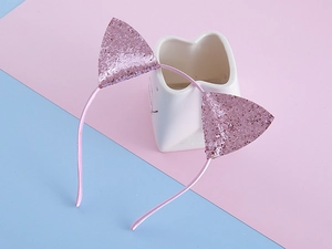 Détail du serre-tête oreilles de chat à paillettes roses avec un ruban en tissu satiné