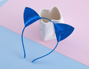 Vue détaillée d'un serre-tête oreilles de chat bleu pailleté sur support céramique