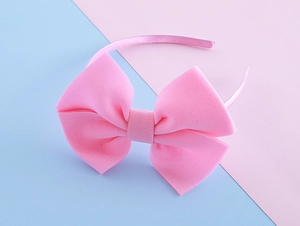 Close-up of pink oversized fabric bow headband with ribbon wrapped band for girls