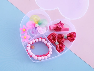 Vue détaillée d'un ensemble bijoux enfant avec pinces fleurs et bracelet perles en boîte