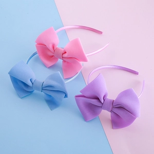 Three elegant oversized bow headbands in pink, blue, and purple for girls' hair styling