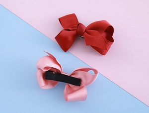 Detail of red and pink ribbed ribbon hair clips with non-slip metal duckbill clip