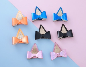 Détail de pinces à cheveux oreilles de chat à paillettes avec nœuds colorés