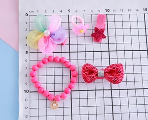 Détail d'un ensemble bijoux rose pour enfant avec pince fleur arc-en-ciel et bracelet