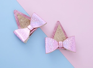 Gros plan de pinces à cheveux oreilles de chien à paillettes roses avec nœud brillant