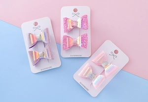 Détail de pinces à cheveux à paillettes faites main en rose et violet sur cartes