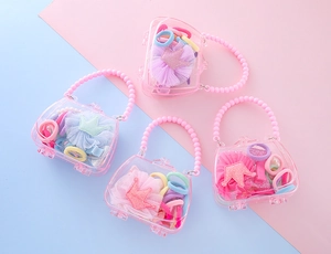 Lot de quatre sacs roses avec divers accessoires de coiffure en forme de couronne enfant