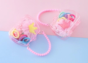 Détail du coffret cadeau couronne rose avec nœuds à paillettes et accessoires cheveux enfant