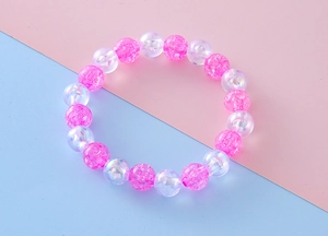 Detailed macro view of pink cracked beads and iridescent clear beads on a cute bracelet