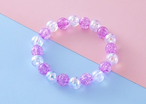Macro shot of purple crackle beads and iridescent white charms on a beaded bracelet
