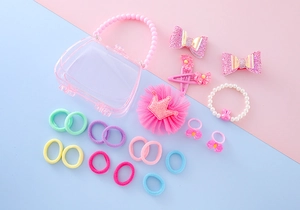 Détail du sac cadeau rose avec pinces couronne, nœuds pailletés et ensemble bijoux