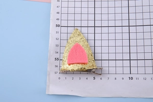 Détail de la pince à cheveux oreille de chien à paillettes sur papier millimétré