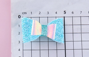 Détail de la pince à cheveux nœud à paillettes bleues de 5 cm montrant taille et texture