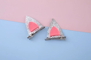 Détail de barrettes oreilles de chien à paillettes argentées avec feutre rose et clip