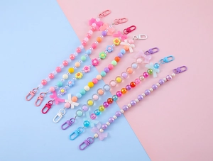 Detailed view of colorful bow and flower beaded keychains with plastic lobster clasps