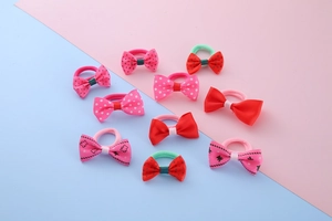 Detailed flat lay of ten colorful bow hair ties with cute patterns for girls
