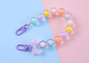 Detail of colorful macaron beaded keychain with purple lobster clasp and bow decoration
