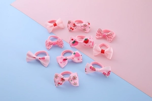 Detail view of 10 pink bow hair ties with cute strawberry and polka dot prints