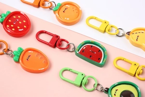 Close-up of colorful resin fruit keychains featuring cute faces and vibrant colors