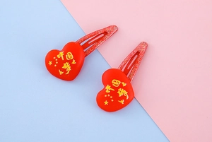 Détail de barrettes à cheveux coeur rouge avec motif d'étoiles et fini pailleté