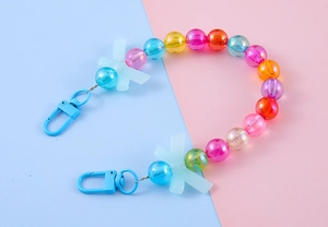 Detail of colorful beaded chain with white resin bows and blue lobster clasps