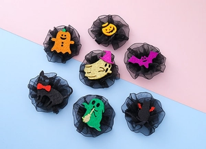 Detailed view of Halloween hair clips featuring pumpkins, ghosts, and bats on black tulle