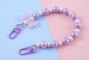 Detailed view of purple bead chain strap with iridescent bow and metal lobster clasps
