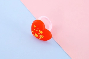 Détail d'une bague coeur en résine rouge avec imprimé étoile de Chine pour enfants