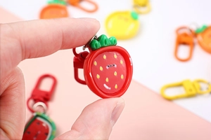 Close-up of cute strawberry resin keychain with metal clasp for school bag decoration