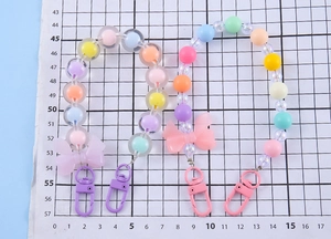 Detail of colorful macaron beaded keychains with resin bows and metallic clasps