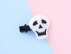 Close-up of a cartoon skull hair clip on a pastel background for Halloween party