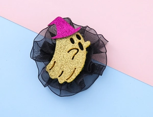 Macro detail of Halloween ghost hair clip with gold glitter and black mesh ruffle
