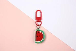 Close-up of cute cartoon watermelon resin keychain with a red metal lobster clasp