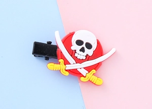 Detail showing a pirate skull and crossbones motif on a black metal hair clip base