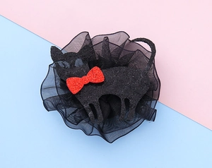 Detail of black glitter cat hair clip with red bow and mesh ruffles for Halloween