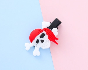Close-up of a pirate skull hair clip with a red headscarf and black alligator clip