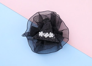 Detail of Halloween witch hat hair clip with black sequins and silver flowers on lace