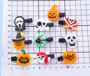 Detail view of 9-piece Halloween hair clips with ghost and pumpkin motifs on grid background