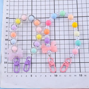Pastel color beaded bow charms with flowers and lobster clasps on a grid background