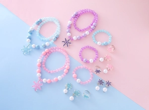 Close-up of beaded snowflake necklaces and rings in pastel macaron colors for girls