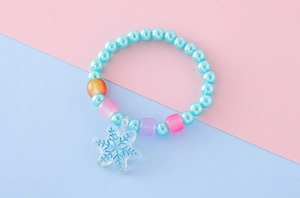 Dettaglio del braccialetto di perline colorate per bambine con ciondolo a fiocco di neve
