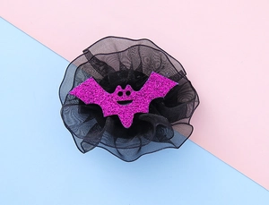 Detail of Halloween hair clip featuring a purple glitter bat with black lace mesh backing