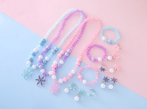 Close-up of beaded snowflake jewelry sets for girls including necklaces and rings