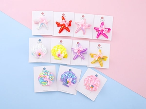 Detailed view of sequined starfish and shell hair clips with tulle bows on card