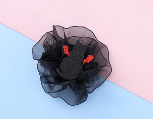 Detail of Halloween hair clip featuring black mesh gauze and cat with red bat wings