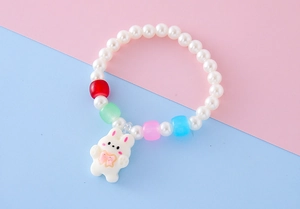 Dettaglio di un braccialetto di perline per bambini con perle e ciondolo a coniglio