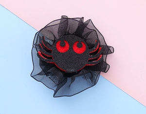 Detail of cute black spider hair clip with red eyes and lace trim for Halloween parties